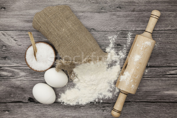 Wheat flour in a canvas bag, a large salt shaker wood, raw eggs, a wooden rolling pin: set for makin Stock photo © mcherevan