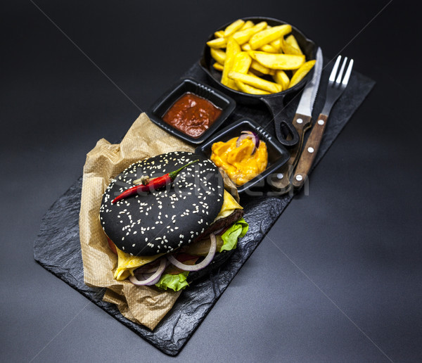 Set of the black burger. Stone plate with: black burger roll slices of juicy marble beef, fused chee Stock photo © mcherevan