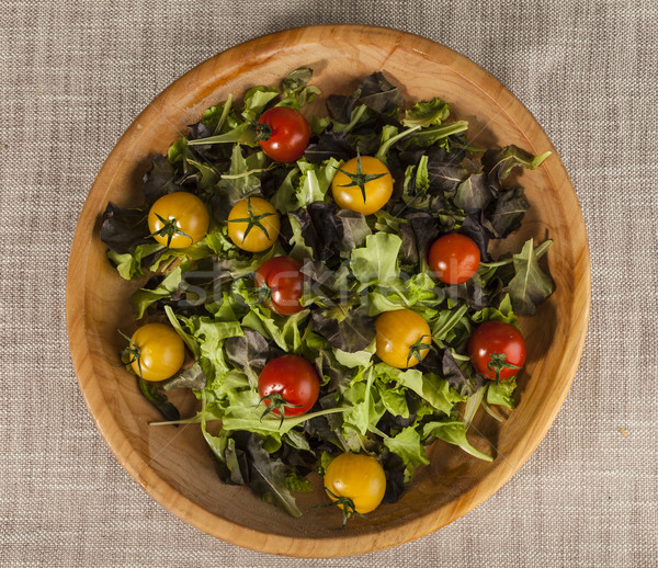 Fresh lettuce and red and yellow cherry tomatoes on a wooden tray Stock photo © mcherevan