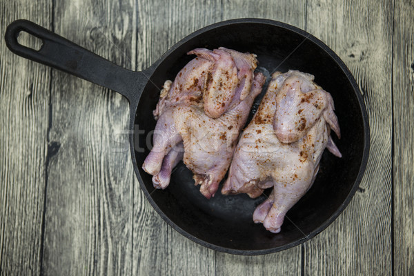 Two raw fresh chicken on iron pan  over wooden background. Stock photo © mcherevan
