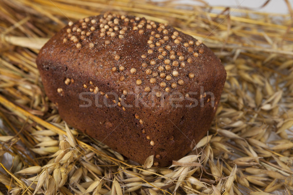 Loaf of homemade bread with black mustard seeds on table with rye spikelets  and oats Stock photo © mcherevan