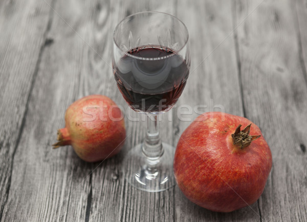 Two fruit juicy Spanish pomegranate and glass of pomegranate wine on a wooden background. Stock photo © mcherevan