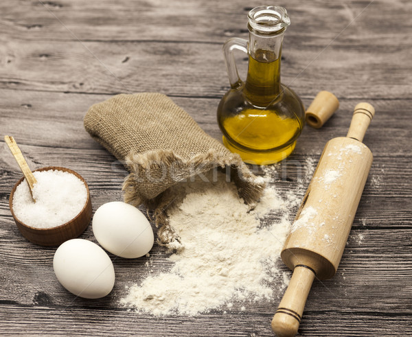 Wheat flour in a canvas bag, the olive oil in a glass carafe, a large salt shaker wood, raw eggs, a  Stock photo © mcherevan