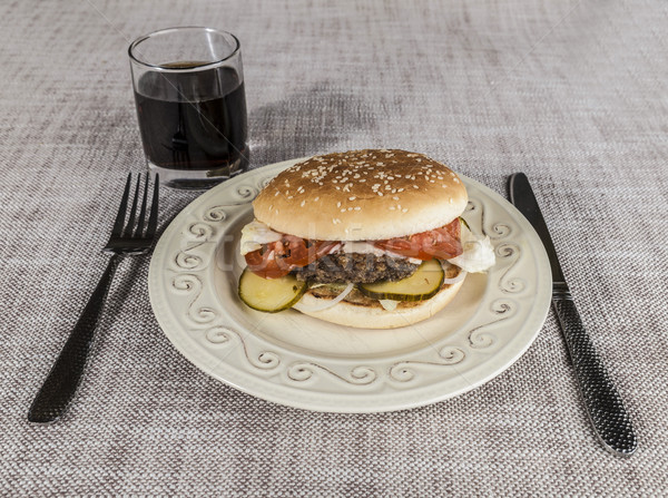 Fresh hamburger with a chop of marbled beef and fresh vegetables on a plate with a fork and knife Stock photo © mcherevan