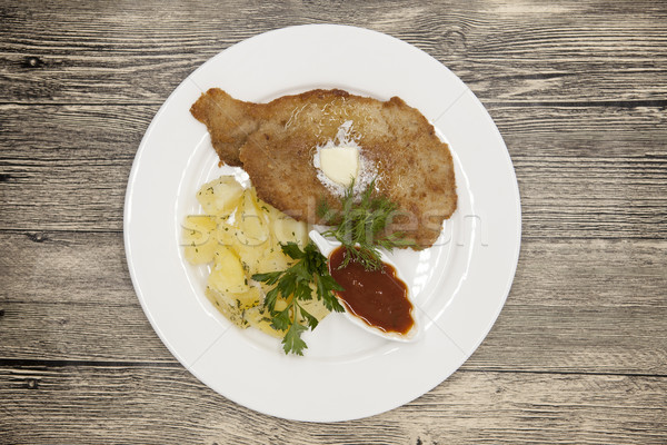 Petite Wiener schnitzel with boiled potatoes and ketchup. Served on a white porcelain plate on a woo Stock photo © mcherevan