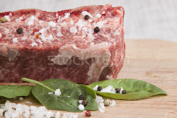 Close-up piece of fresh marbled beef, chili pepper, parsley, onion, garlic, ribs lie on a wooden tra Stock photo © mcherevan