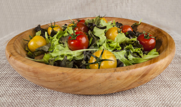 Fresh lettuce and red and yellow cherry tomatoes on a wooden tray Stock photo © mcherevan