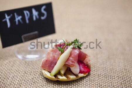 Fresh delicious Spanish tapas with hamon with fresh herbs and strawberries on the  texture backgroun Stock photo © mcherevan