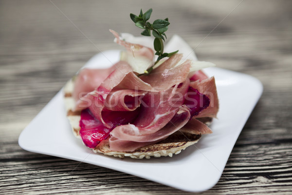 Fresh delicious Spanish tapas with hamon with fresh herbs and strawberries on the  wooden background Stock photo © mcherevan
