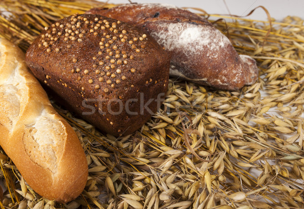 White, black and baguette homemade bread on the table with spikelets of rye and oats Stock photo © mcherevan