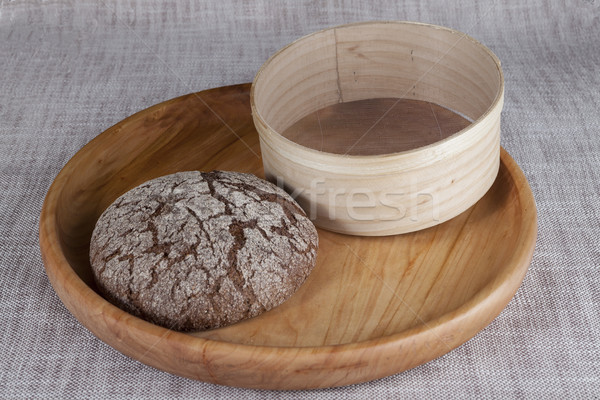 Fresh homemade bread made from durum wheat, rye, on a wooden tray with a sieve for flour.  Stock photo © mcherevan