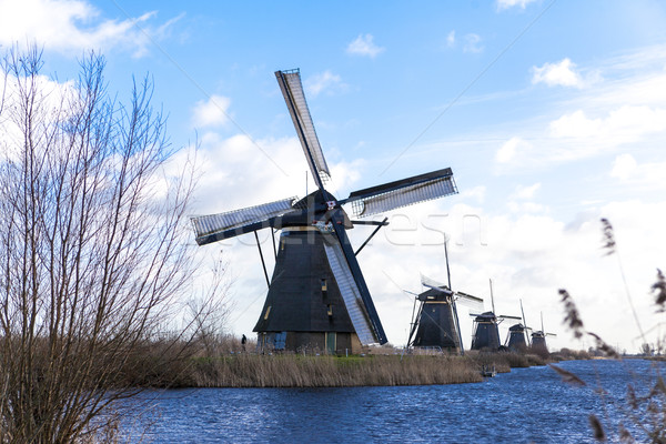 Old, traditional windmill in the Dutch canals. Netherlands.White clouds on a blue sky, the wind is b Stock photo © mcherevan