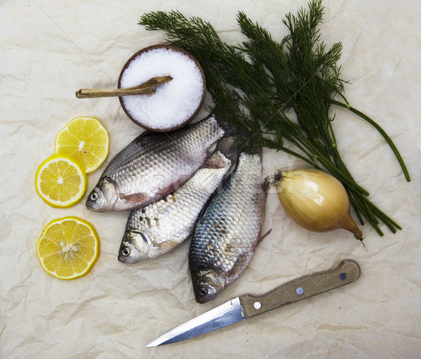 A  fresh carp live fish lying on a on paper background with a knife and slices of lemon and with sal Stock photo © mcherevan