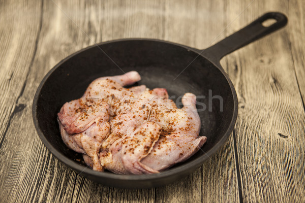 Raw fresh chicken on iron pan over wooden background. Stock photo © mcherevan