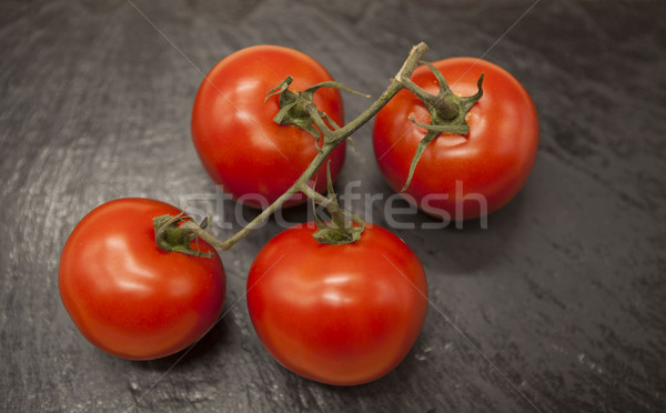Fresh branch of red Sicilian ripe tomatoes on a stone background Stock photo © mcherevan