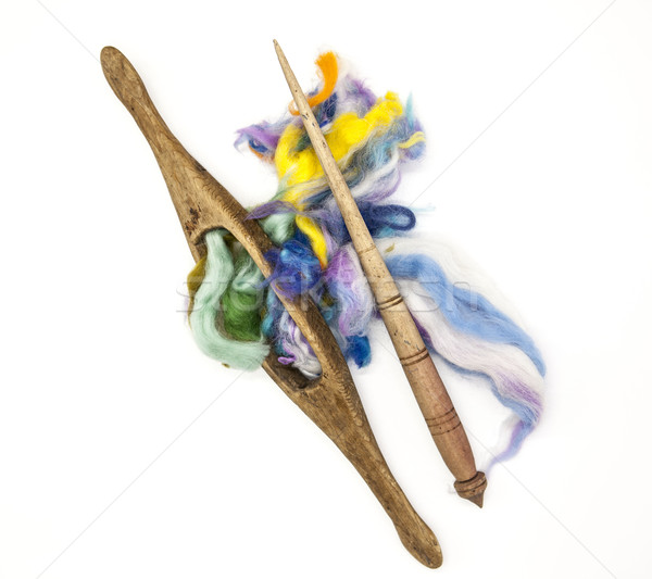 Colored hair and old spindle close-up on white background. Tools for knitting of wool Stock photo © mcherevan