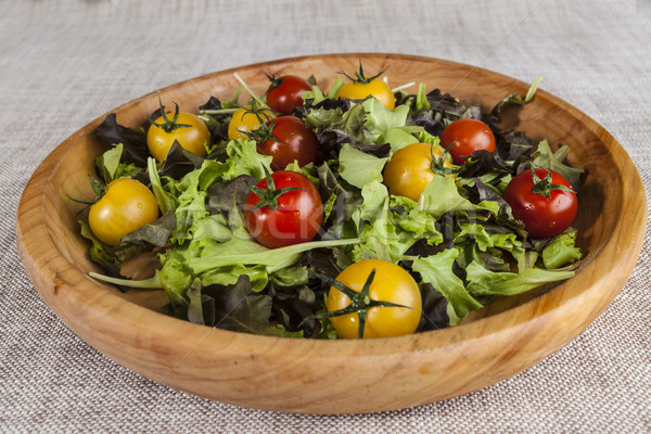 Fresh lettuce and red and yellow cherry tomatoes on a wooden tray Stock photo © mcherevan