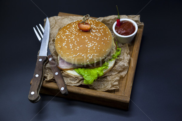 Classical American fresh juicy burger with chicken and ham on a wooden tray with a spicy chili sauce Stock photo © mcherevan