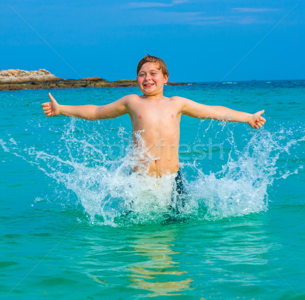 young happy boy with brown hair enjoys swimming and jumping in the beautiful sea Stock photo © meinzahn