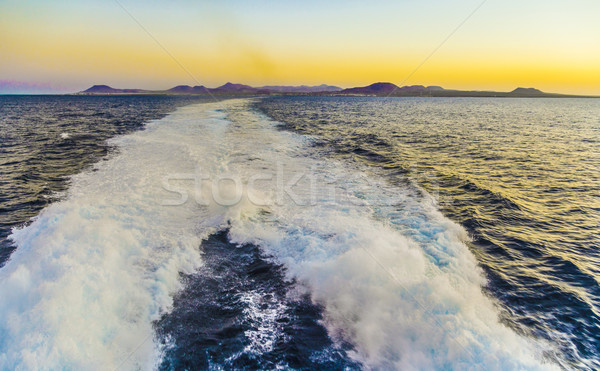 Stock photo: trail of the ship with the island in the background