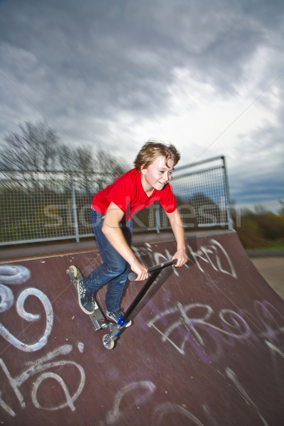 Boy going airborne with a scooter Stock photo © meinzahn