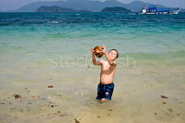 boy is playing with a coconut on a beautiful beach Stock photo © meinzahn