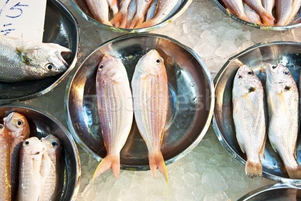 whole fresh fishes are offered in the fish market in asia Stock photo © meinzahn