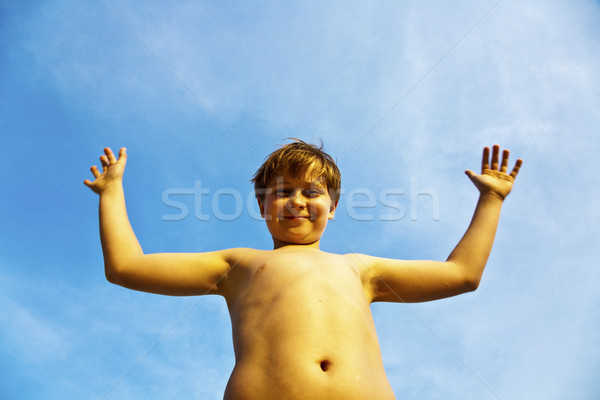 happy smiling young boy with background blue sky irises up his a Stock photo © meinzahn