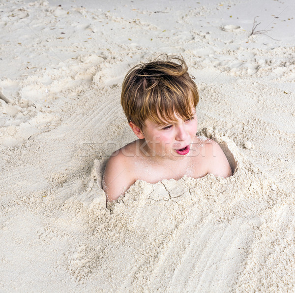 young boy covered by fine sand at the beach Stock photo © meinzahn