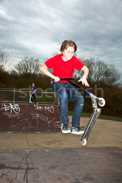 Boy going airborne with a scooter Stock photo © meinzahn