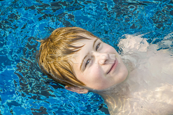 Menino flutuante de volta piscina feliz jovem Foto stock © meinzahn