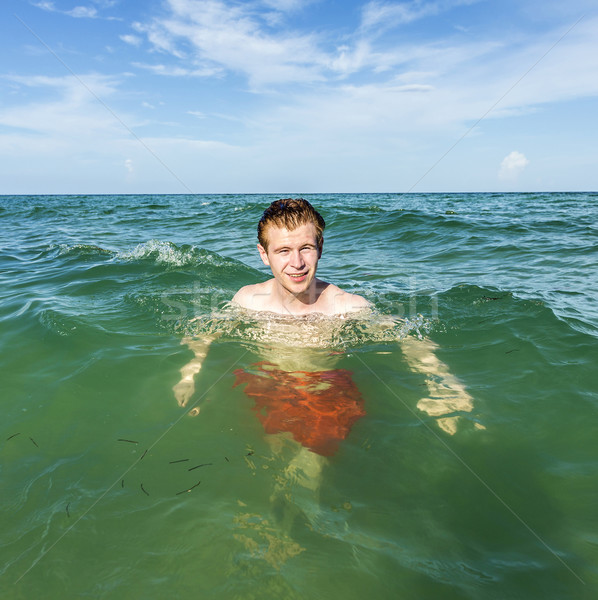 Tizenéves fiú úszik óceán trópusi tengerpart víz Stock fotó © meinzahn