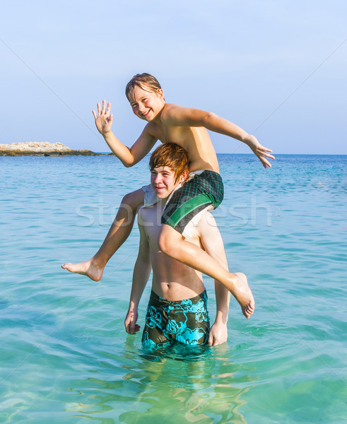 brothers playing piggyback in the ocean Stock photo © meinzahn
