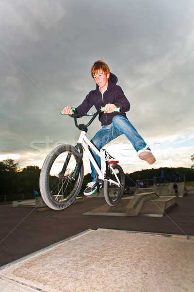young red haired boy is jumping with his BMX Bike at the skate p Stock photo © meinzahn