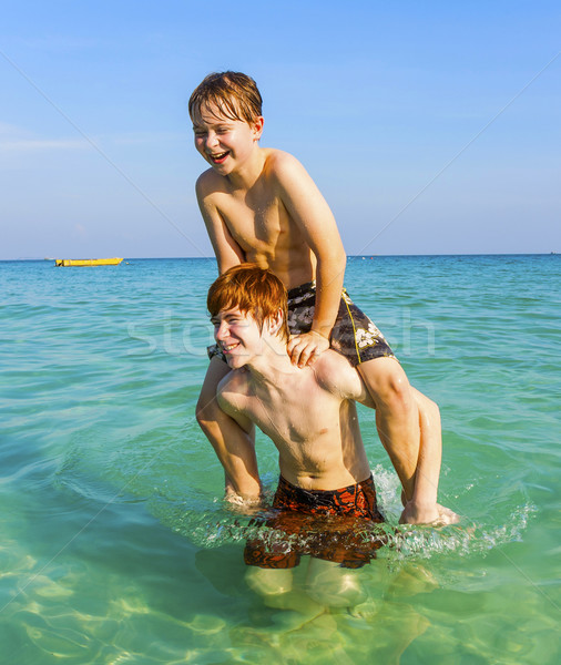 Stock photo: brothers are enjoying the clear warm water in the ocean and play