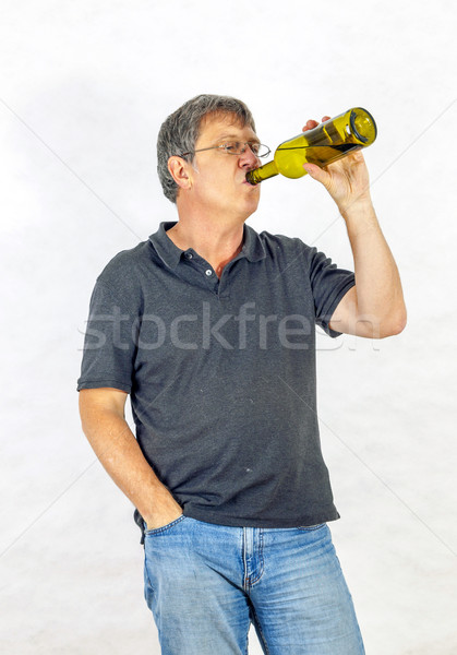 man drinks alcohol out of a bottle Stock photo © meinzahn