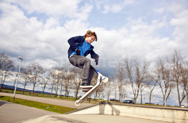Boy going airborne with a scooter Stock photo © meinzahn