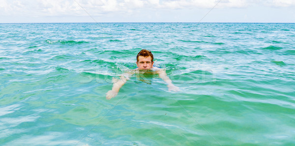 teenage boy enjoys swimming in the ocean  Stock photo © meinzahn