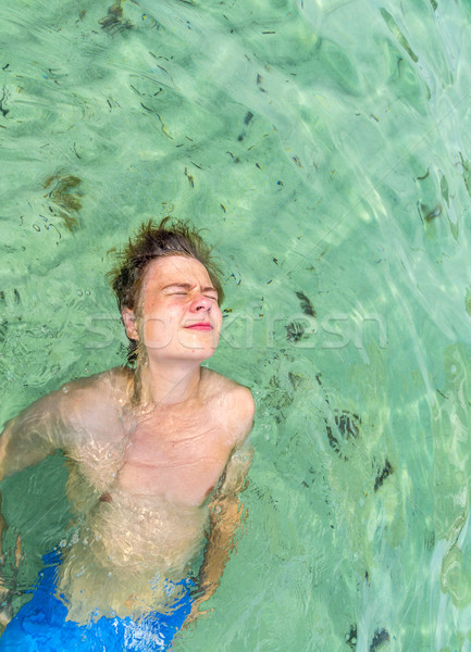 handsome teen has fun playing dead mens float in the ocean Stock photo © meinzahn
