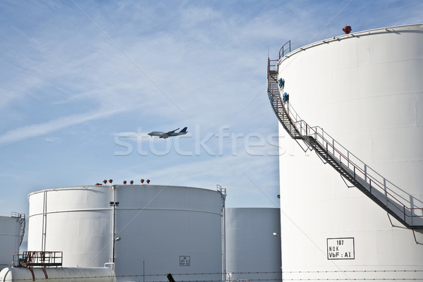white tanks in tank farm with blue sky and approaching aircraft Stock photo © meinzahn
