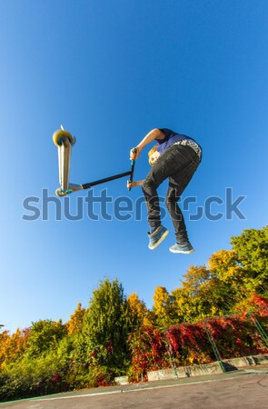 Stock photo: Boy going airborne with a scooter