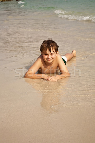 boy iy lying at the beach and enjoying the warmness of the water Stock photo © meinzahn