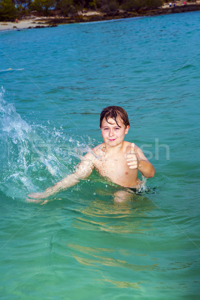 handsome boy has fun in the ocean and shows thumbs up Stock photo © meinzahn