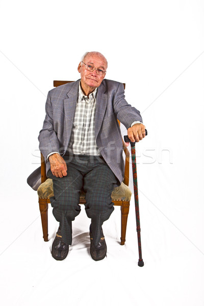 old man sitting in the armchair with his walking stick Stock photo © meinzahn