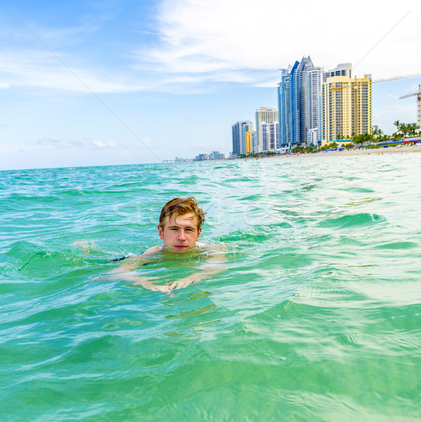 teenage boy enjoys swimming in the ocean  Stock photo © meinzahn
