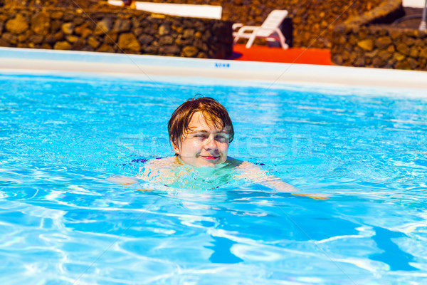 cute handsome teenage boy swims in the pool Stock photo © meinzahn