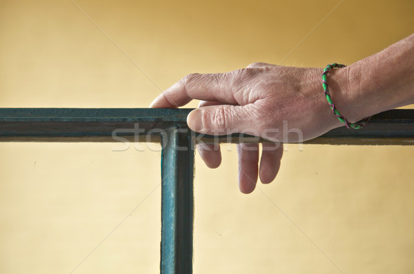 hand with bracelet leaning on a window frame Stock photo © meinzahn