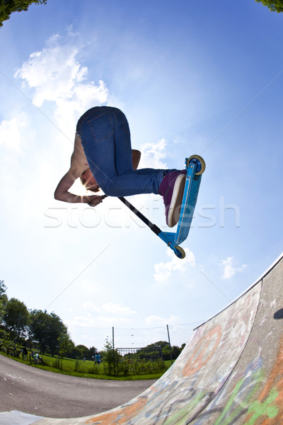 Stock photo: young boy going airborne with a scooter