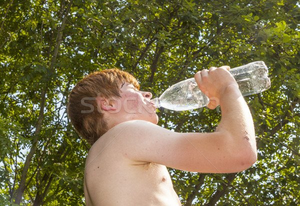 young boy drinks water out of a bottle in the heat  Stock photo © meinzahn