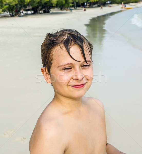 young happy boy with brown wet hair is smiling and enjoying the beautiful beach Stock photo © meinzahn